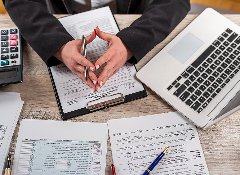 Businessperson reviewing documents and laptop