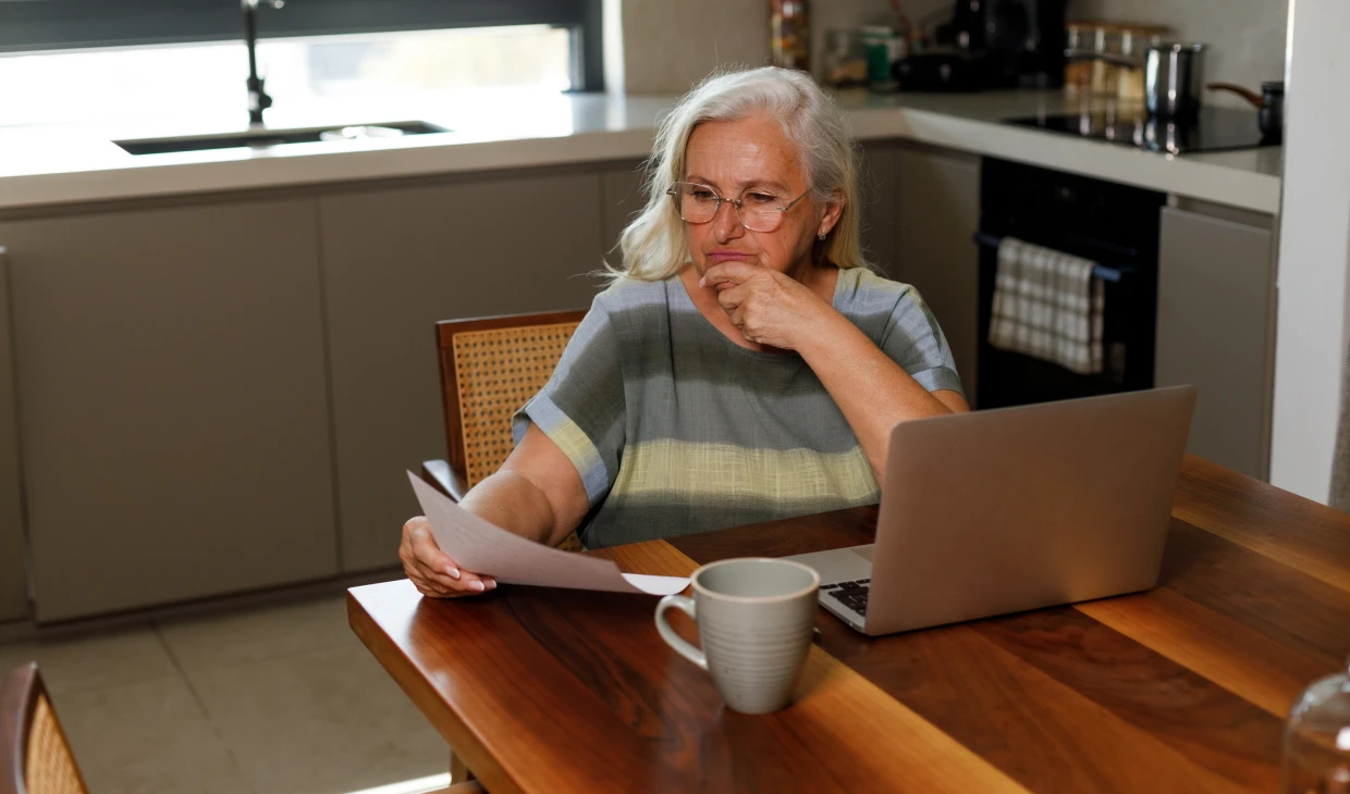 Woman reading documents at kitchen table